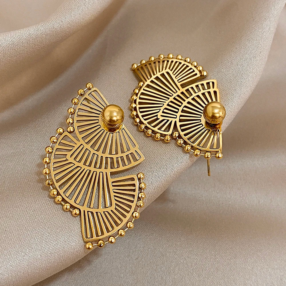 Gold-tone fan-shaped earrings with radiating cutouts and raised round studs
