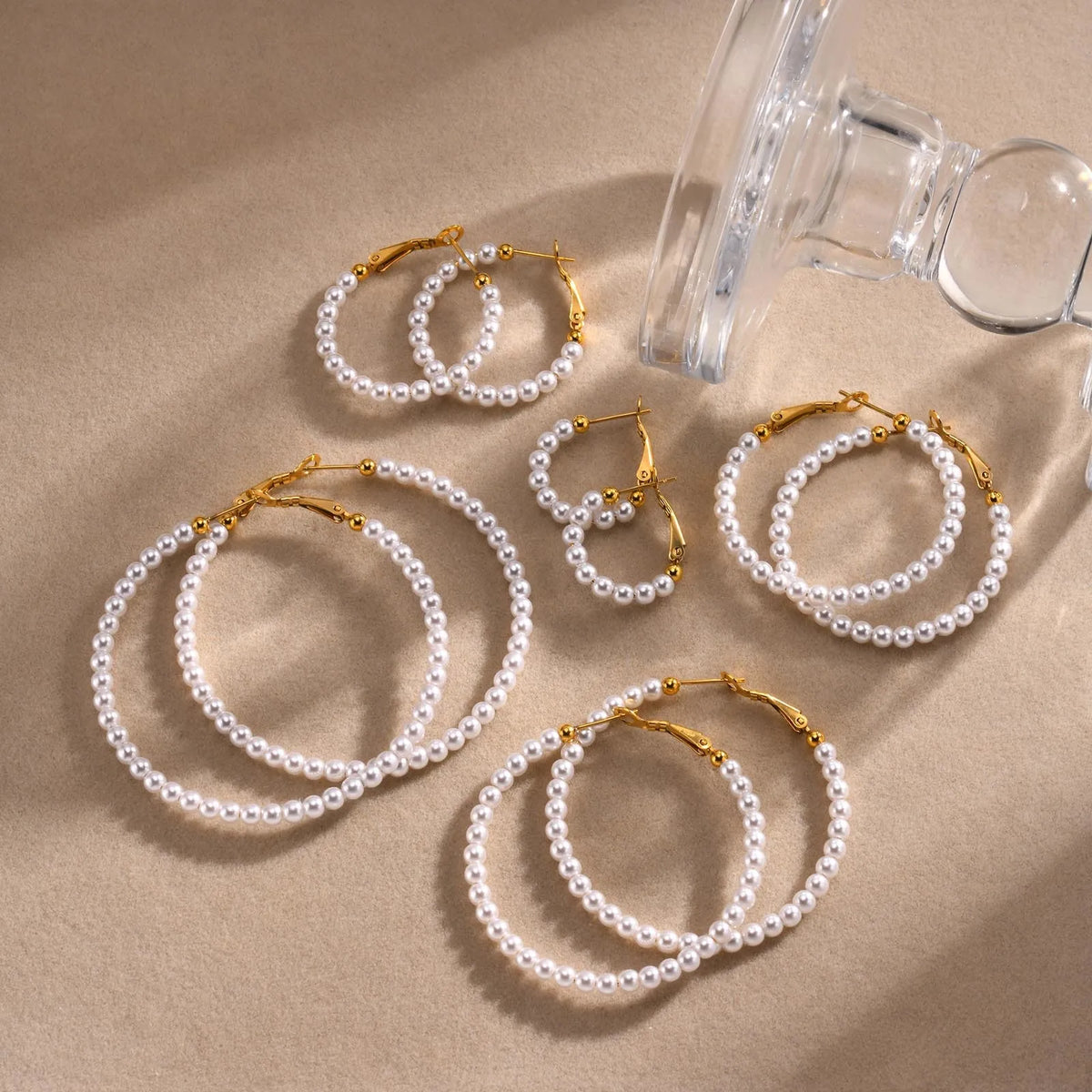 Assorted simulated pearl hoop earrings with gold-tone clasps in multiple sizes