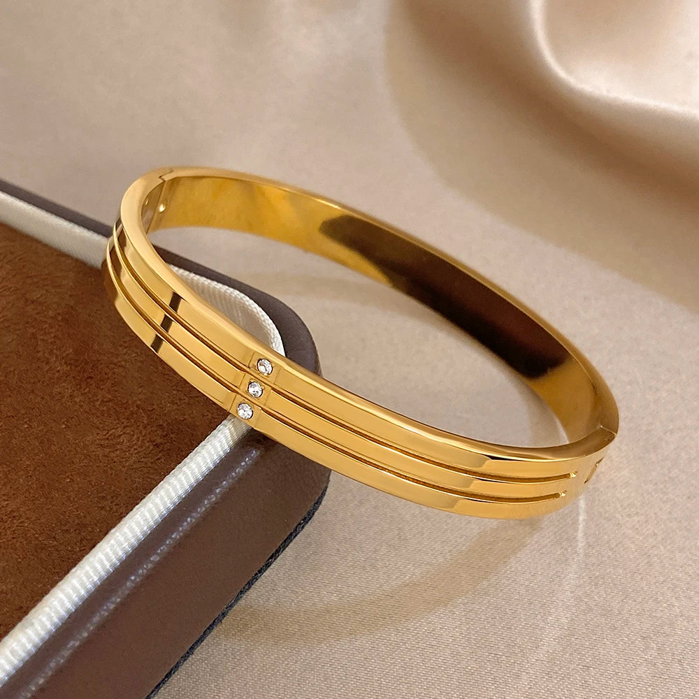 Gold-tone stainless steel wide bangle with crystal stripe detail