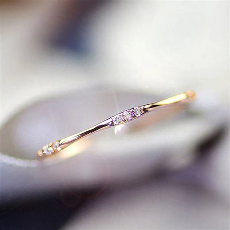 Minimalist cubic zirconia wedding ring, gold-tone side view with sparkling stone row