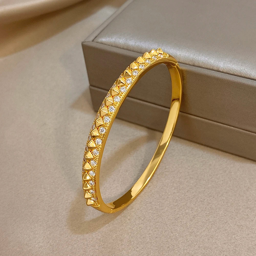 Gold-plated geometric zirconia rivet cuff bangle angled view with faceted stones