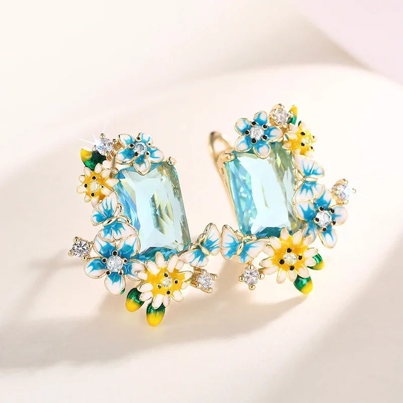Gold-tone floral drop earrings with aqua crystal center and yellow, blue, green flower accents