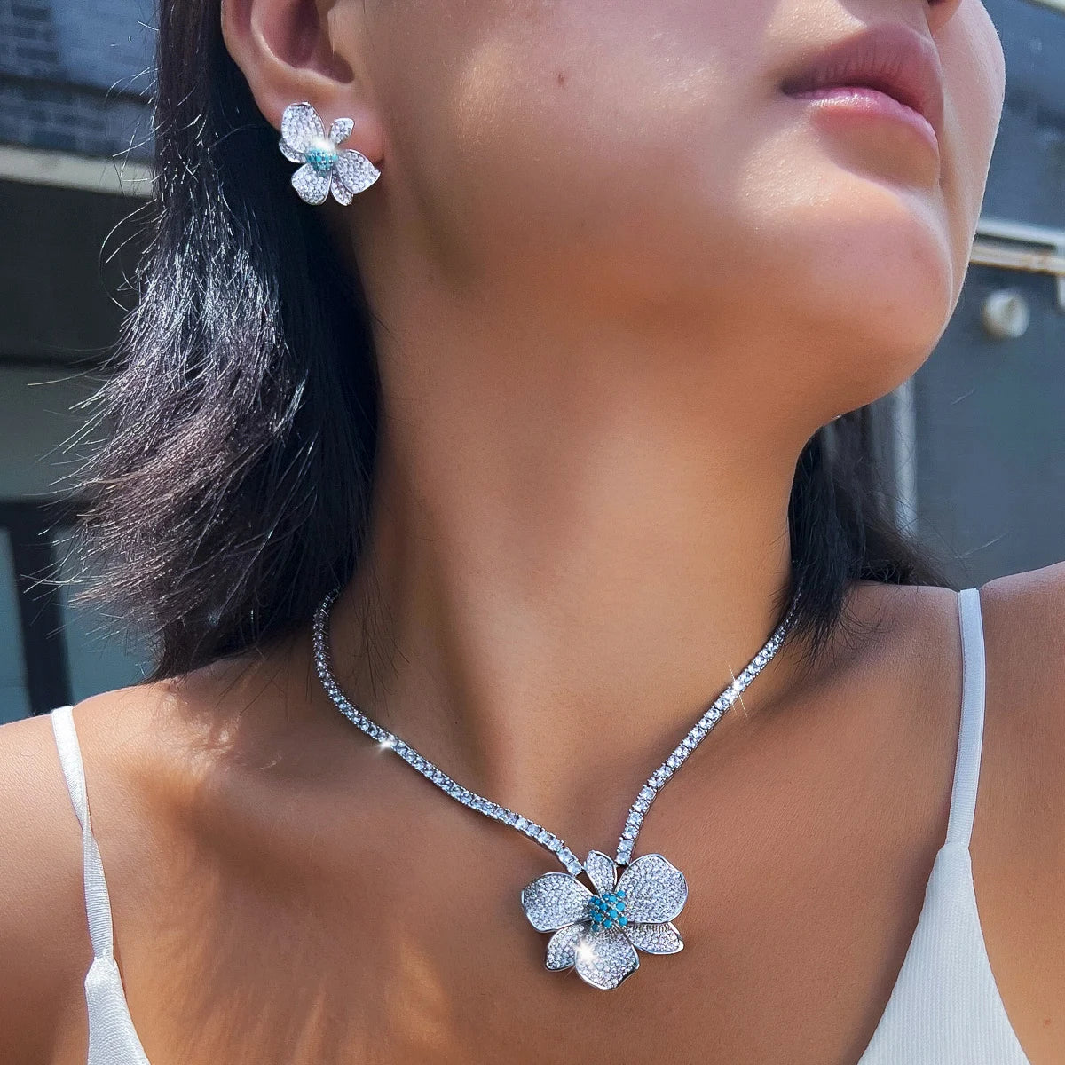 Flower crystal pendant necklace with matching stud earrings, shown worn