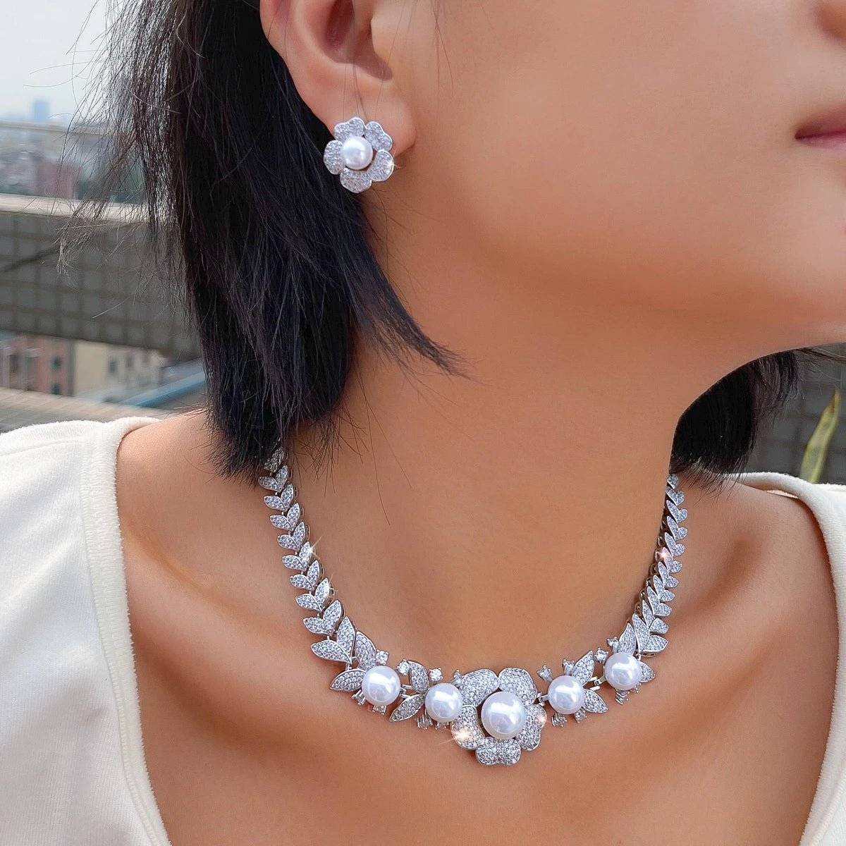 Flower stud earring and matching pearl-accent necklace shown worn