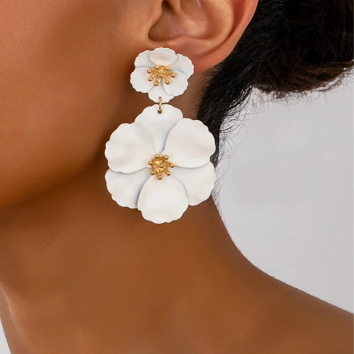 White flower drop earrings with double floral design and gold-tone accents