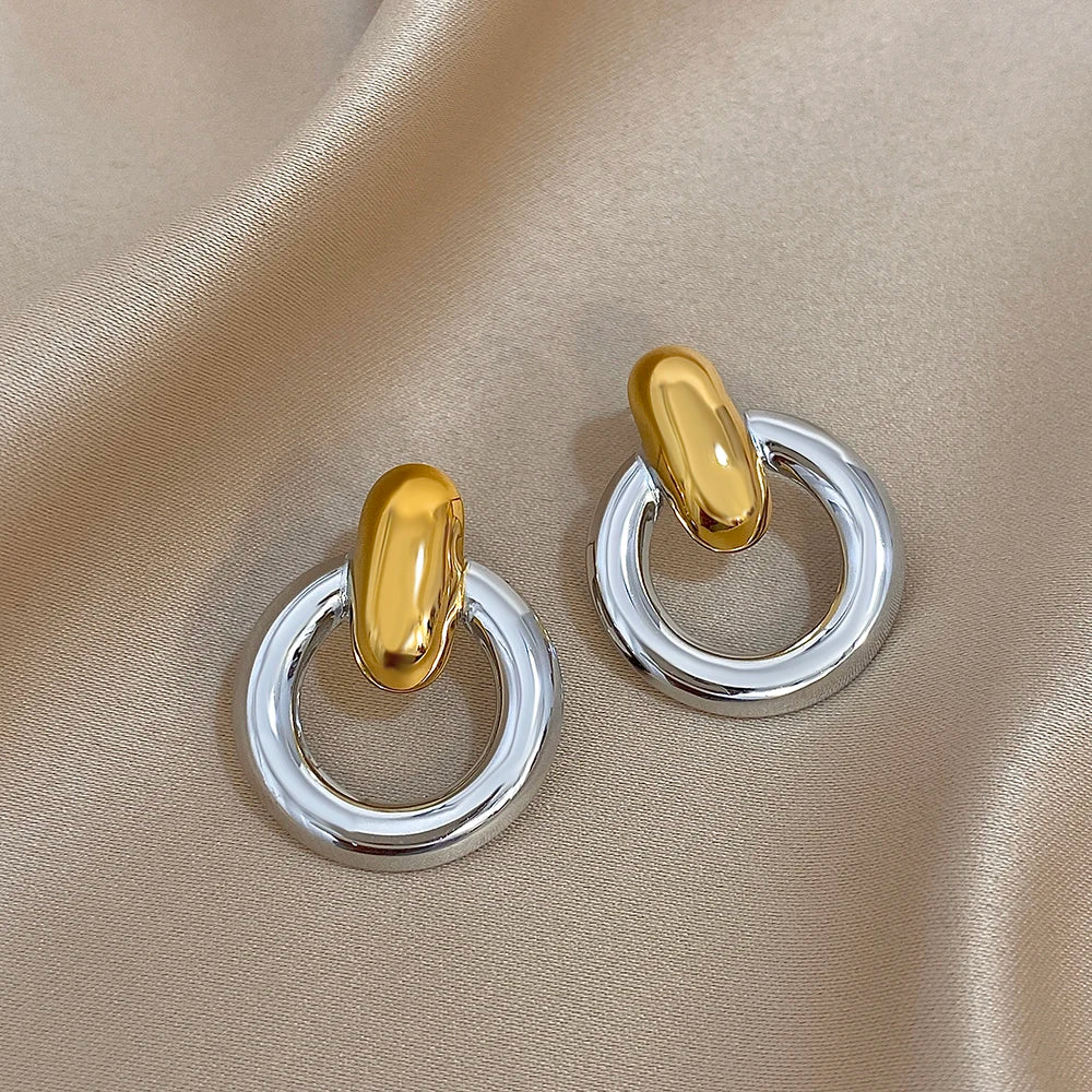 Gold-tone stud earrings with silver circular hoops