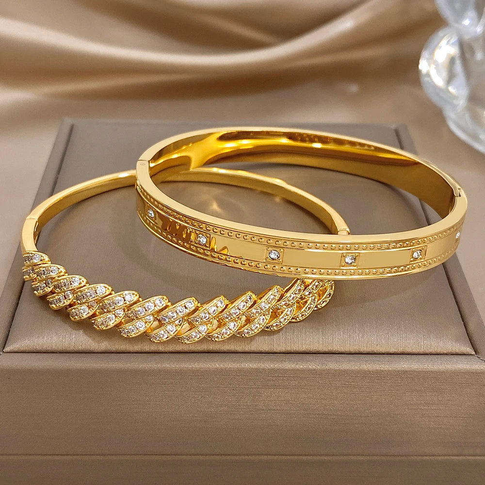 Gold tone bangle set on display: slim cuff with rhinestone rows and link detail.