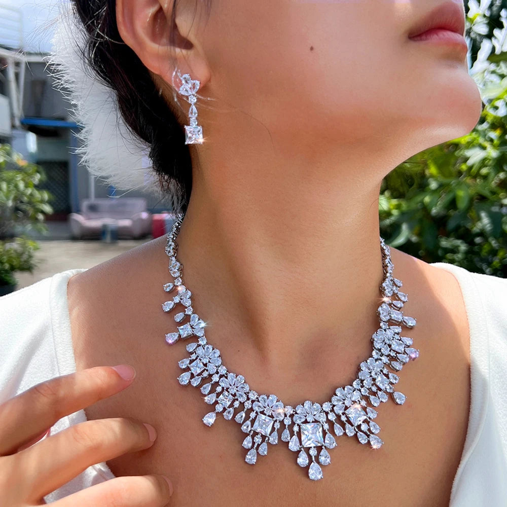 Cubic zirconia necklace and drop earrings set on model, silver-tone stone detailing.