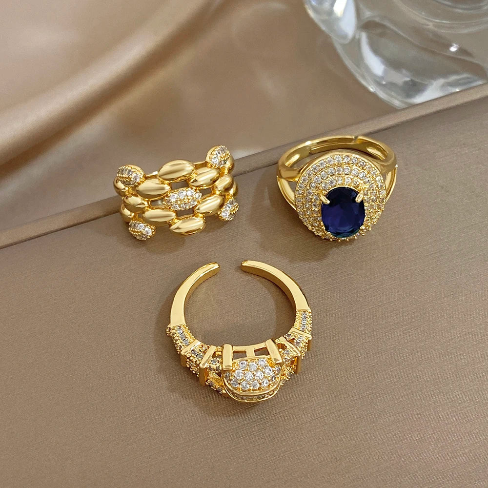Gold-tone zircon open rings set: blue halo ring plus two clear-stone chunky bands