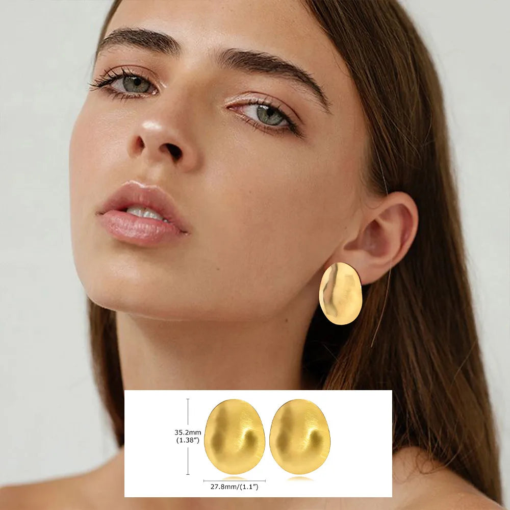 Large gold-tone oval disc stud earrings with a softly concave surface.
