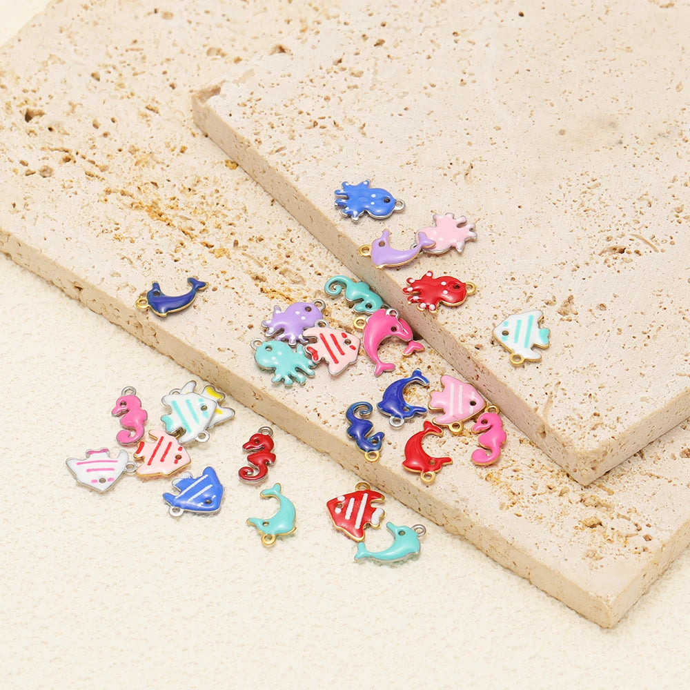 Colorful enamel marine animal charms scattered on a stone block