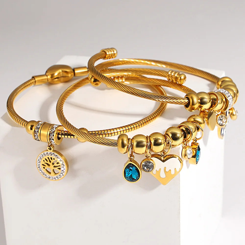 Gold-tone beaded charm bracelet set with blue teardrop heart and crystal detail