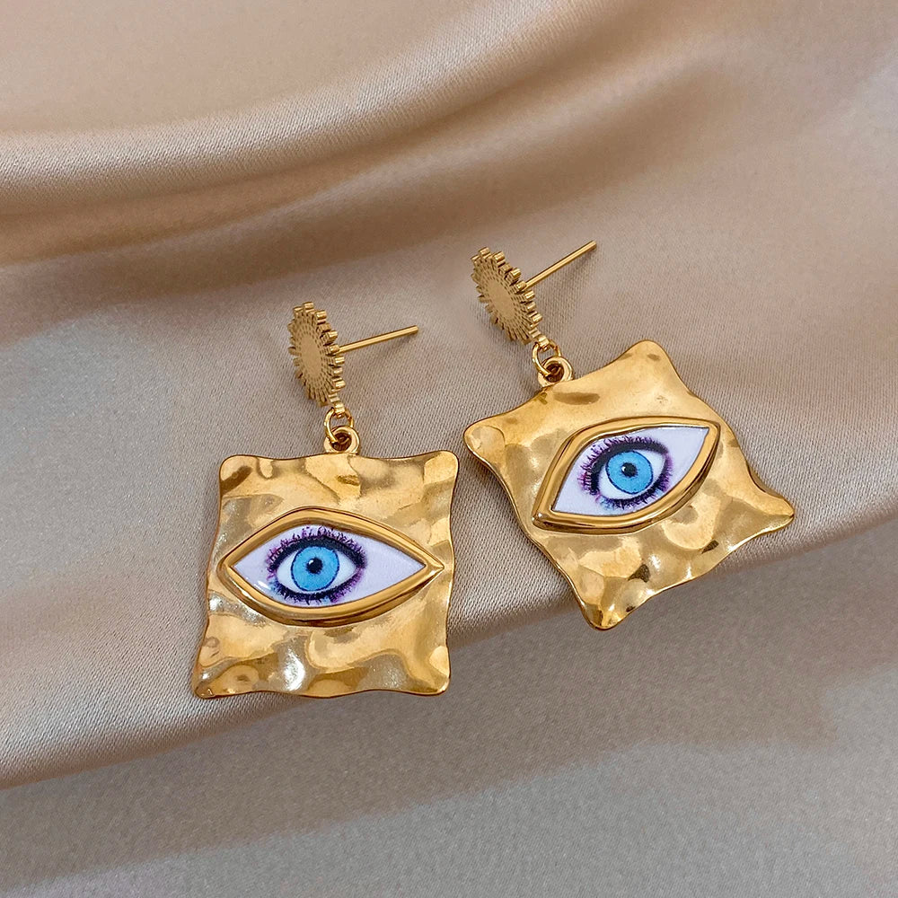 Pair of gold-tone drop earrings with hammered square evil-eye center and gold hook posts