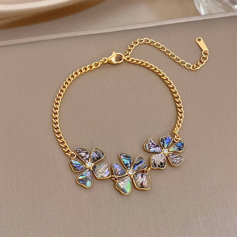 Gold plated chain wrist bracelet with five iridescent flower charms, oval abalone inlays