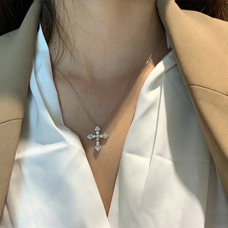 Crystal cross pendant necklace worn with a deep V neckline top