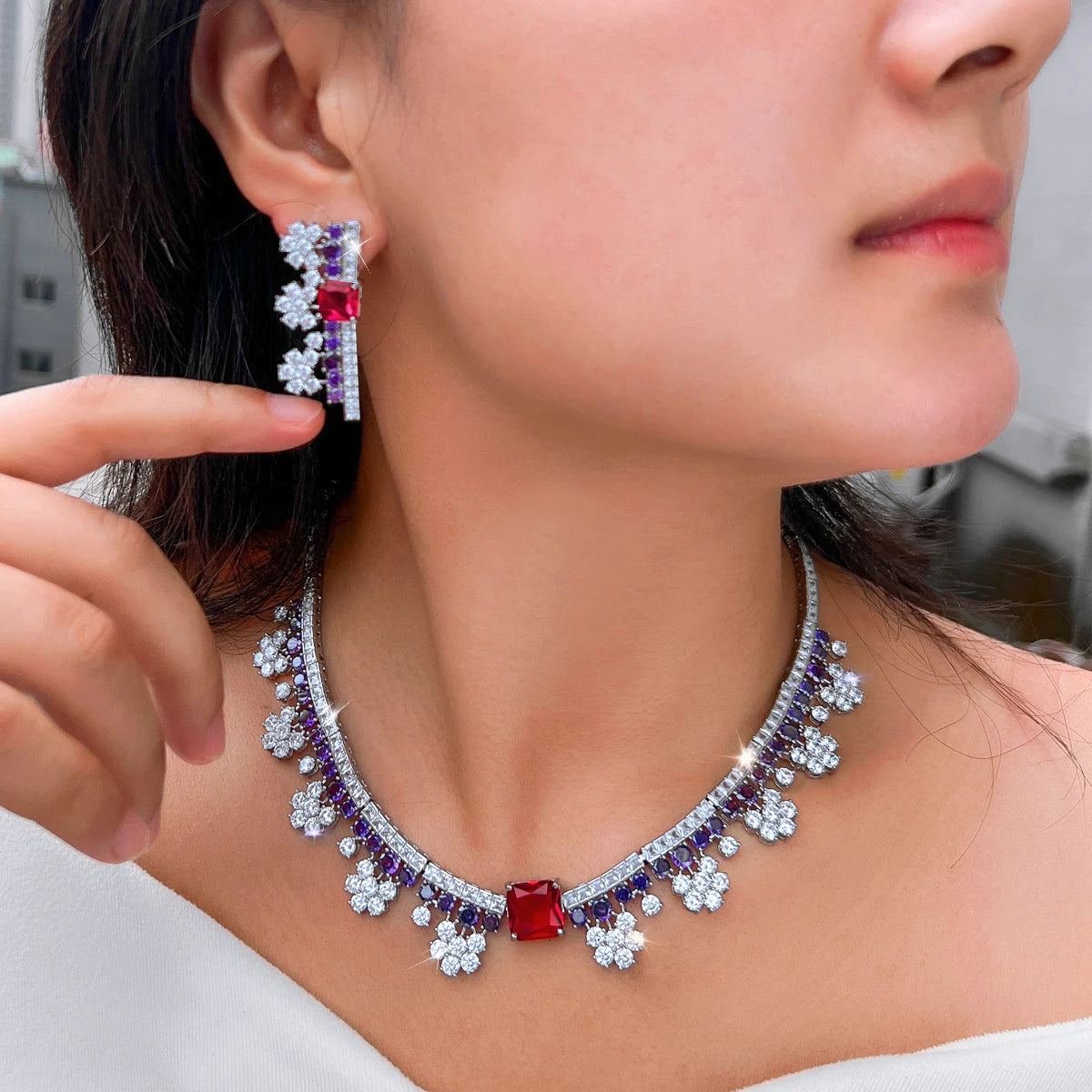 Multicolor crystal choker necklace with red pendant stone and purple starburst details; earrings set