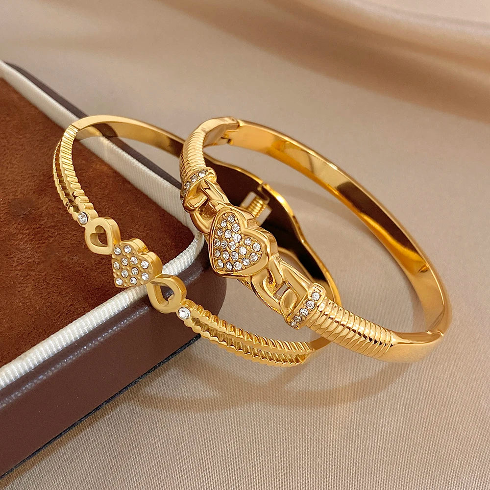Gold-tone heart charm cuff bangle pair with braided rope and rhinestone inlay