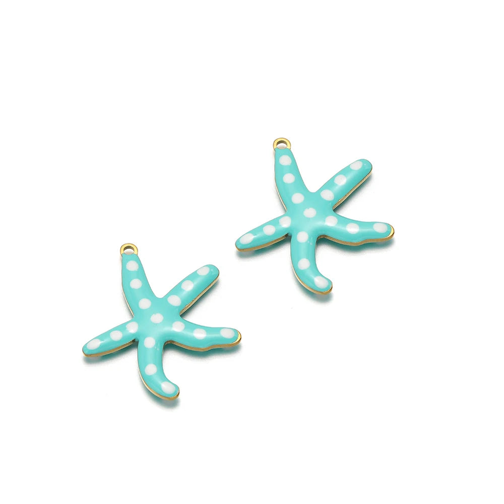Two teal enamel starfish charms with gold-tone loops and white dot accents