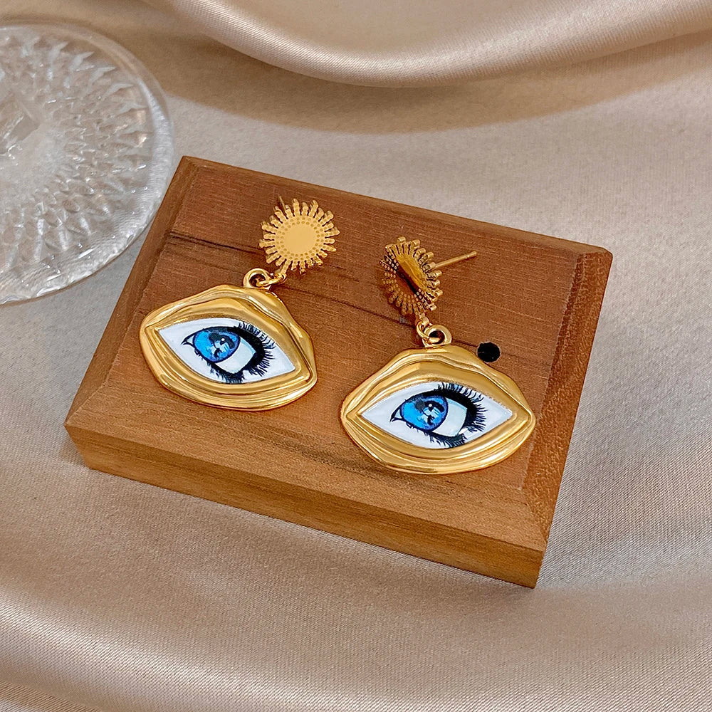 Gold-tone evil eye drop earrings with blue eye enamel, sunburst stud and oval pendant