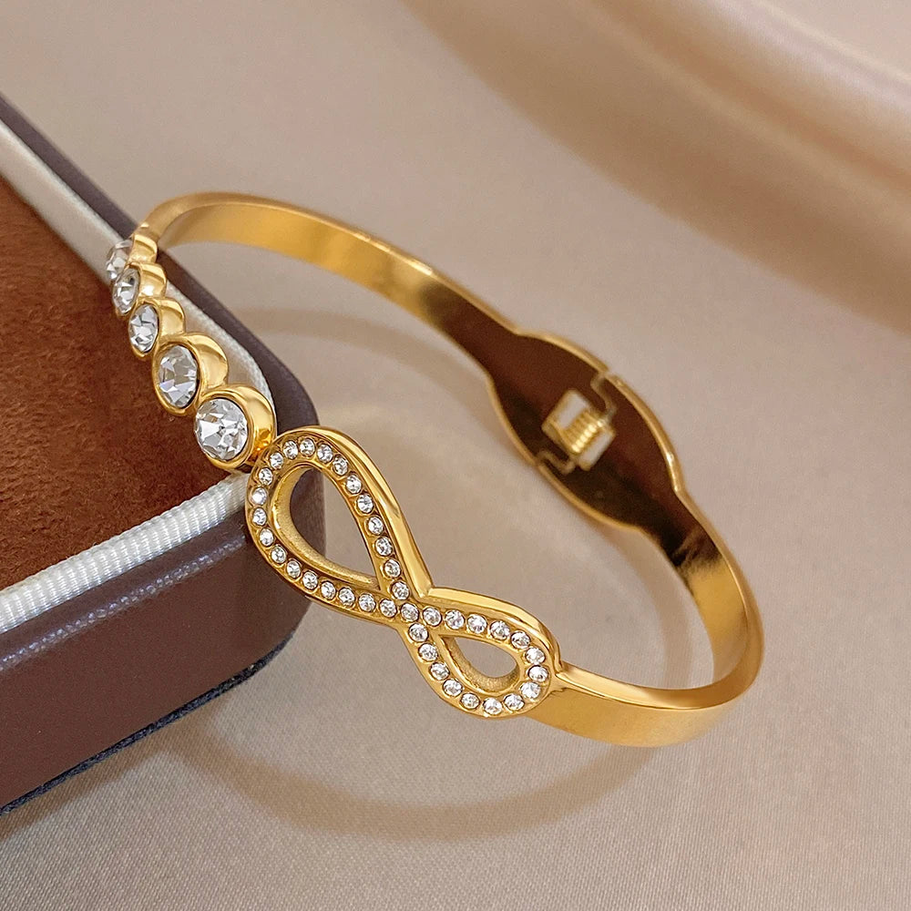 Gold-tone stainless cuff bangle with rhinestone infinity motif and round crystal stones