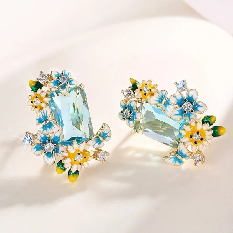 Gold-tone floral drop earrings pair view with aqua crystal center and blue and yellow flowers