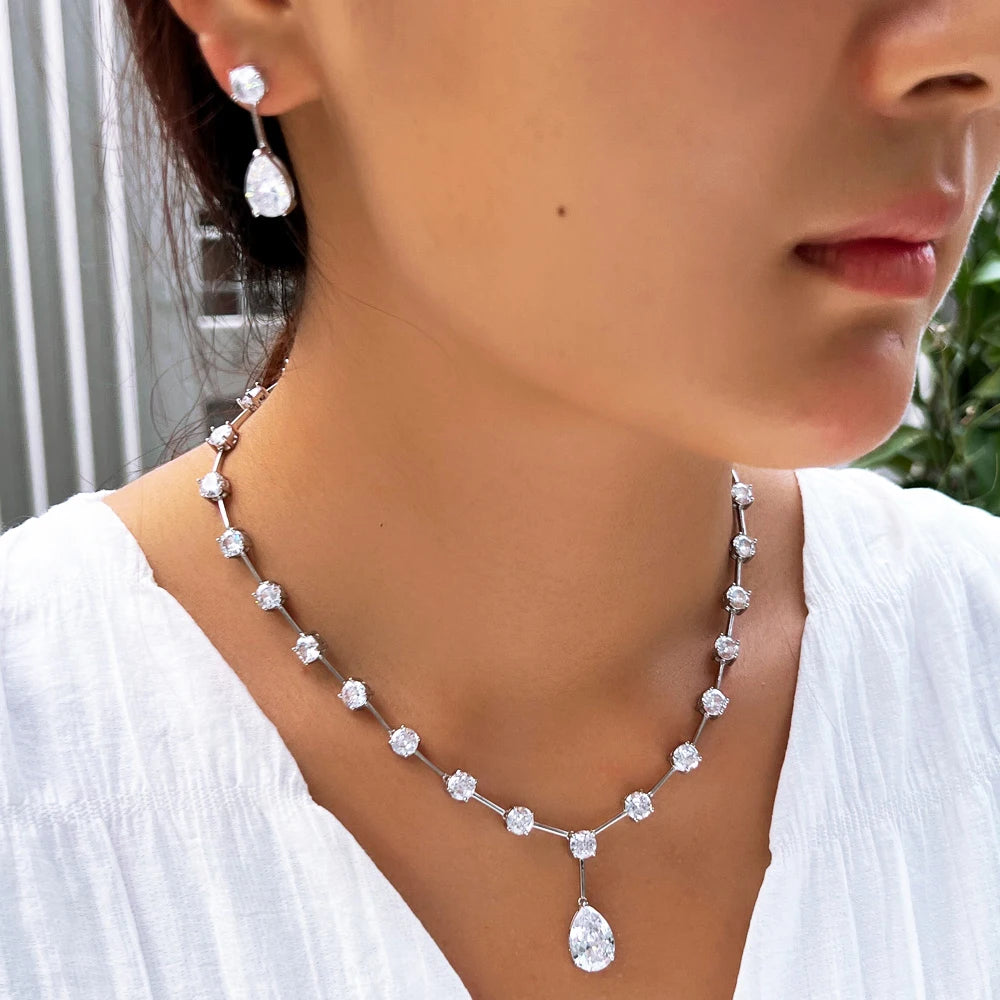 Cubic zirconia necklace and earrings set on model, silver-tone linked stones and teardrop drops