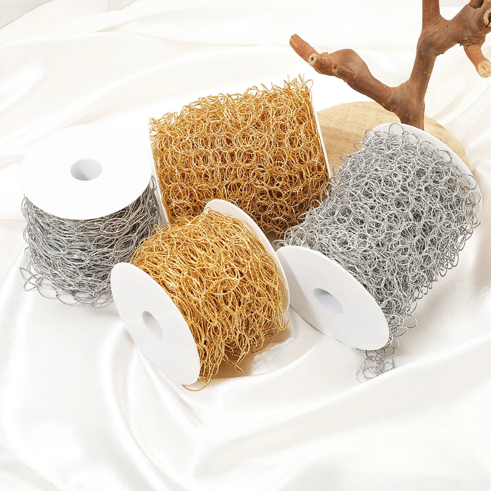 Assorted rolls of gold and silver hollow oval link chain on white spools