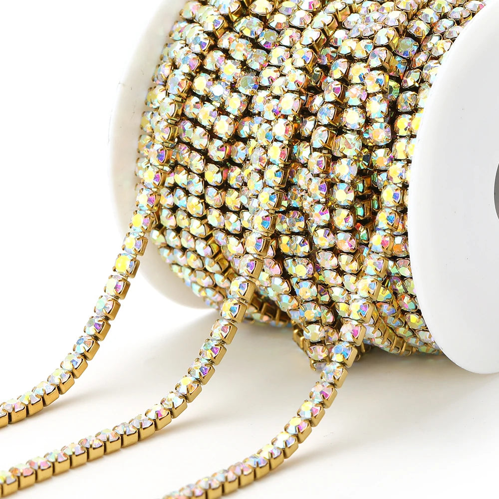 Iridescent holographic rhinestone chain tassel strand on white spool, clear-gold links