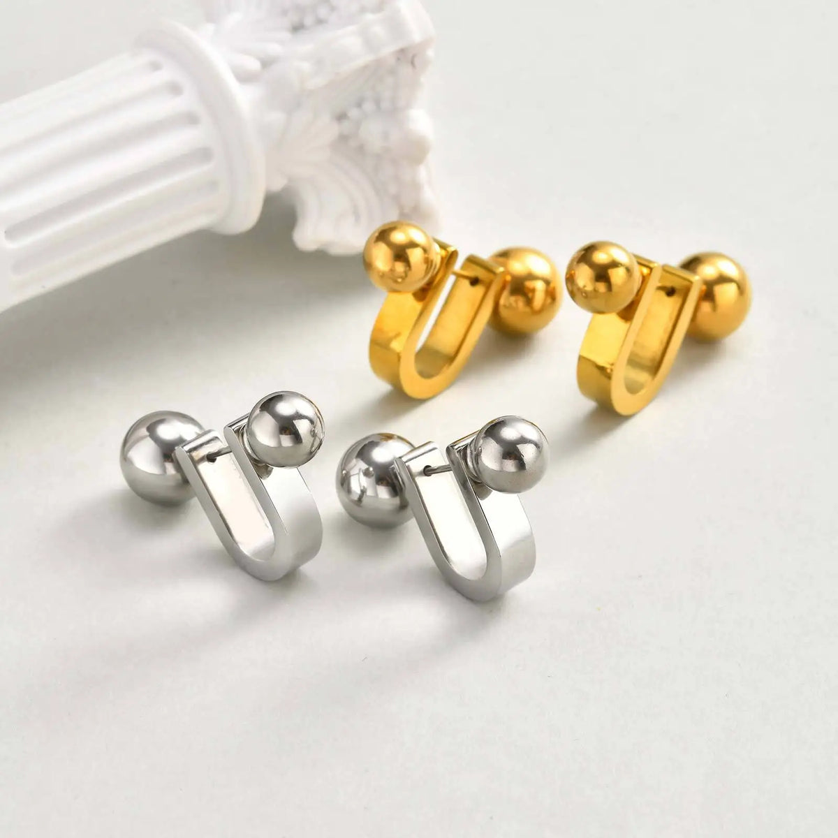 Gold and silver U-shaped hoop earrings with round ball ends