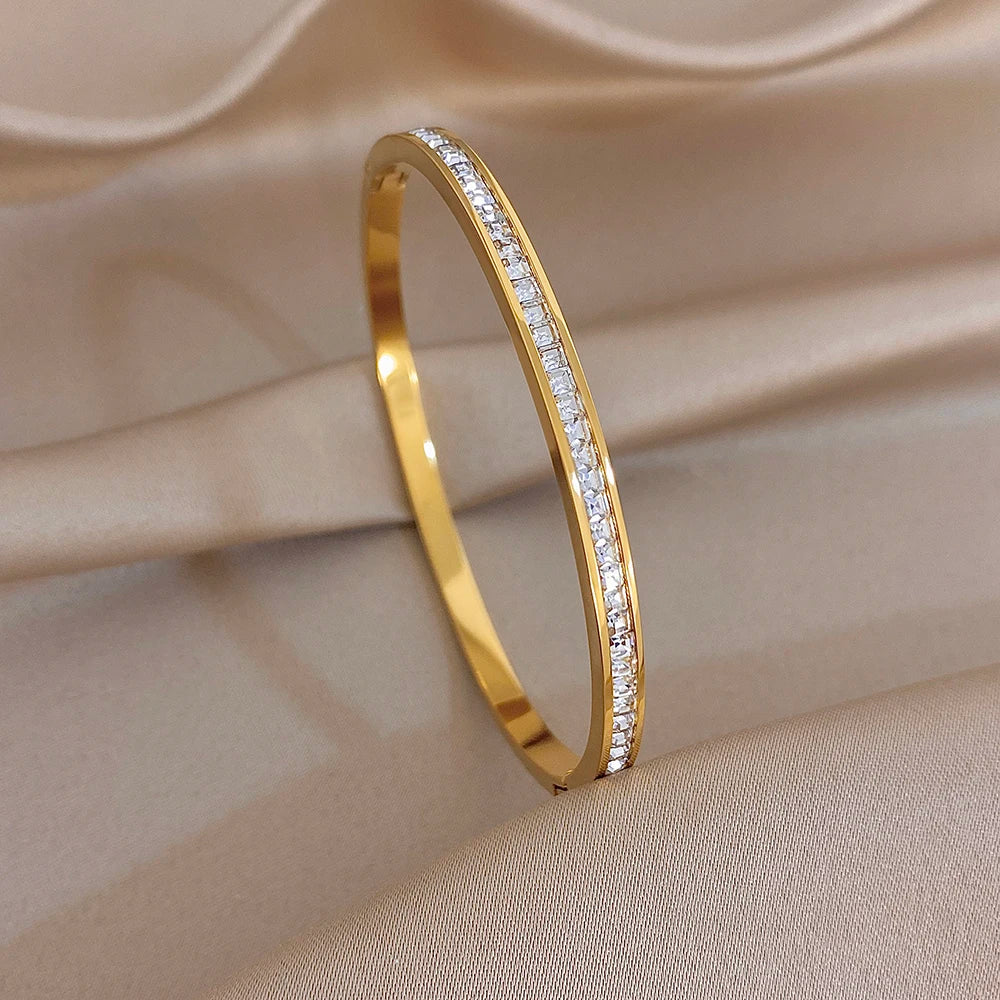 Gold tone slim cuff bangle with continuous rhinestone row