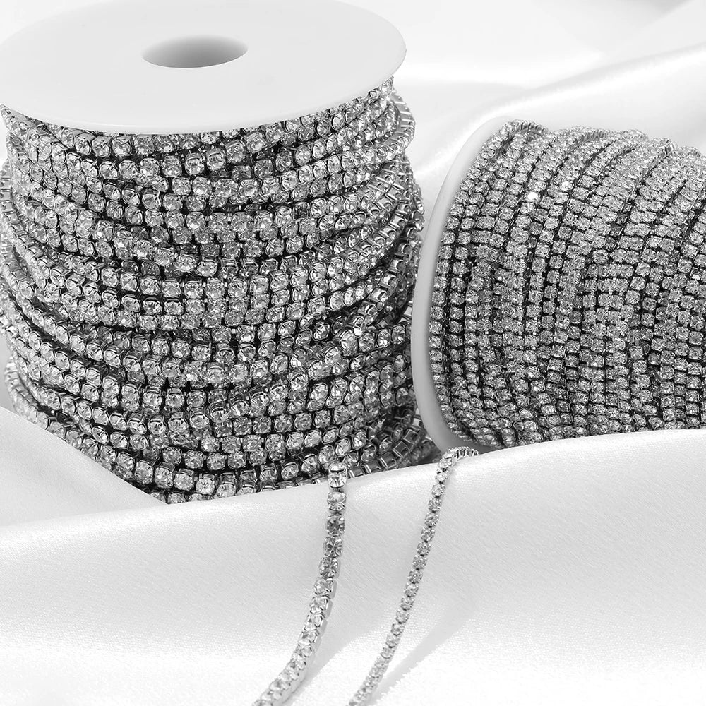 Silver-toned cubic zircon chain rolls on white spools, multiple coiled strands