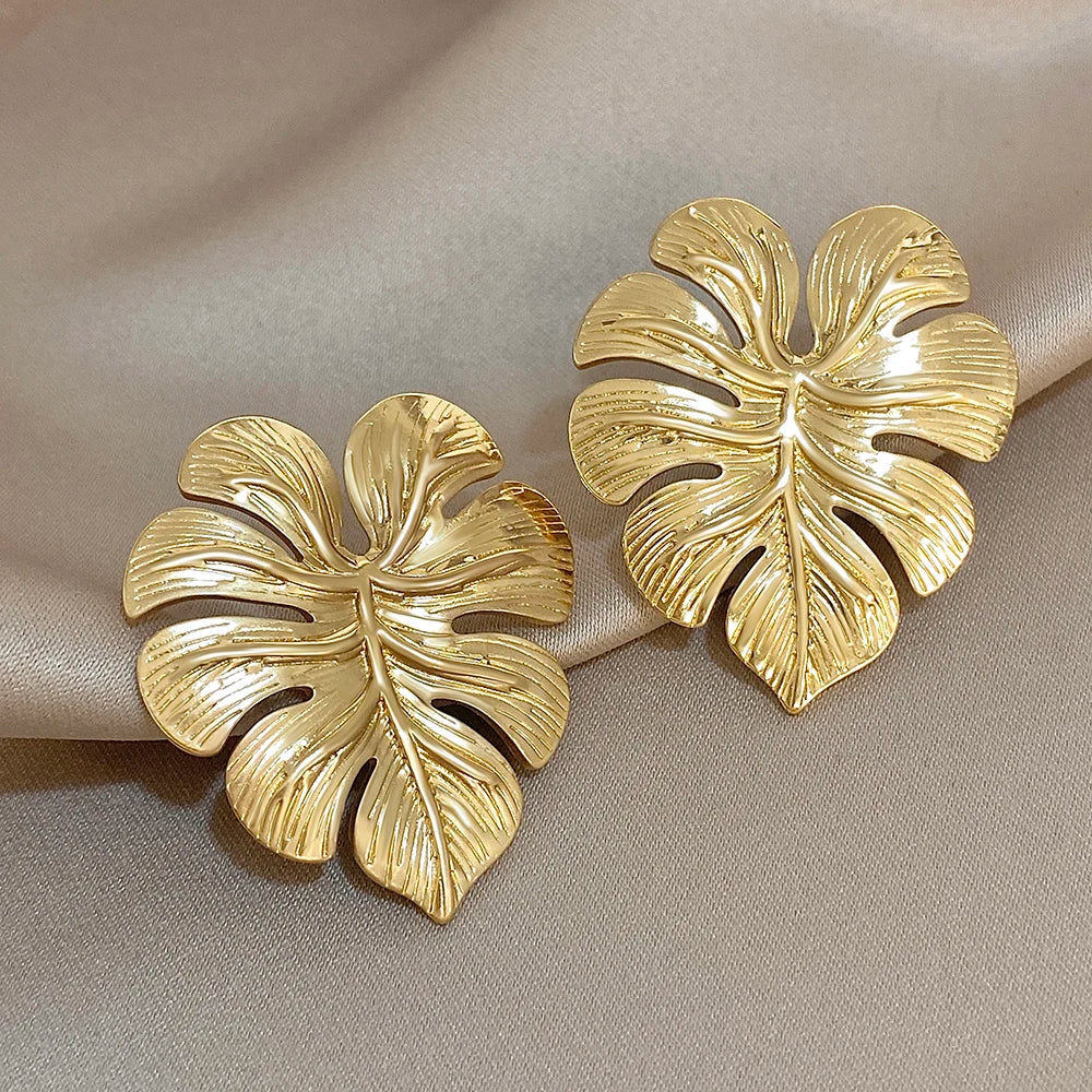 Pair of gold leaf-shaped earrings with raised vein detailing