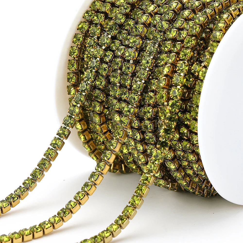 Peridot green rhinestone chain tassel strand with metallic gold links on white spool
