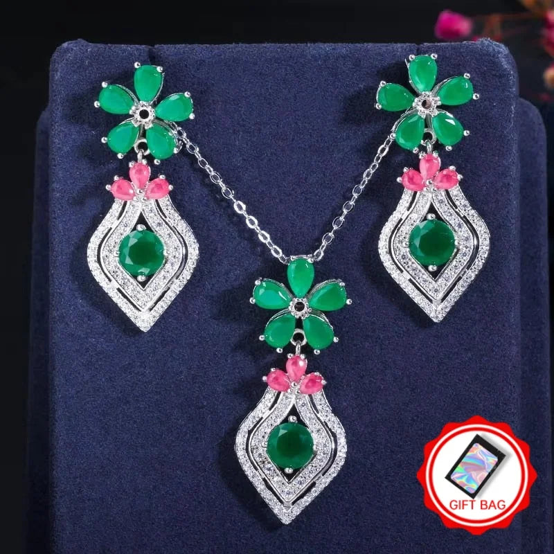 Silver-tone necklace and earrings with green flower motifs, pink accents, and crystal drops