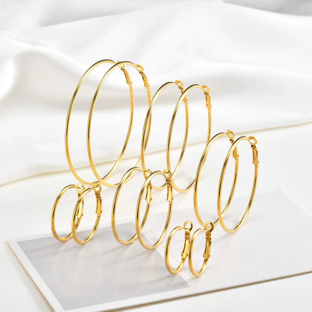 Gold-tone hoop earrings in six sizes, arranged upright.