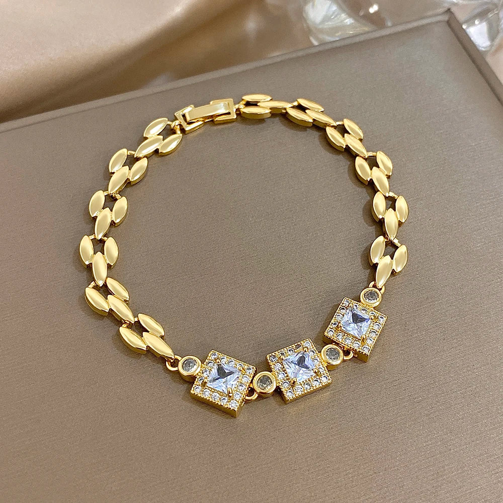 Gold-tone link bracelet with square blue stones and round rhinestone accents