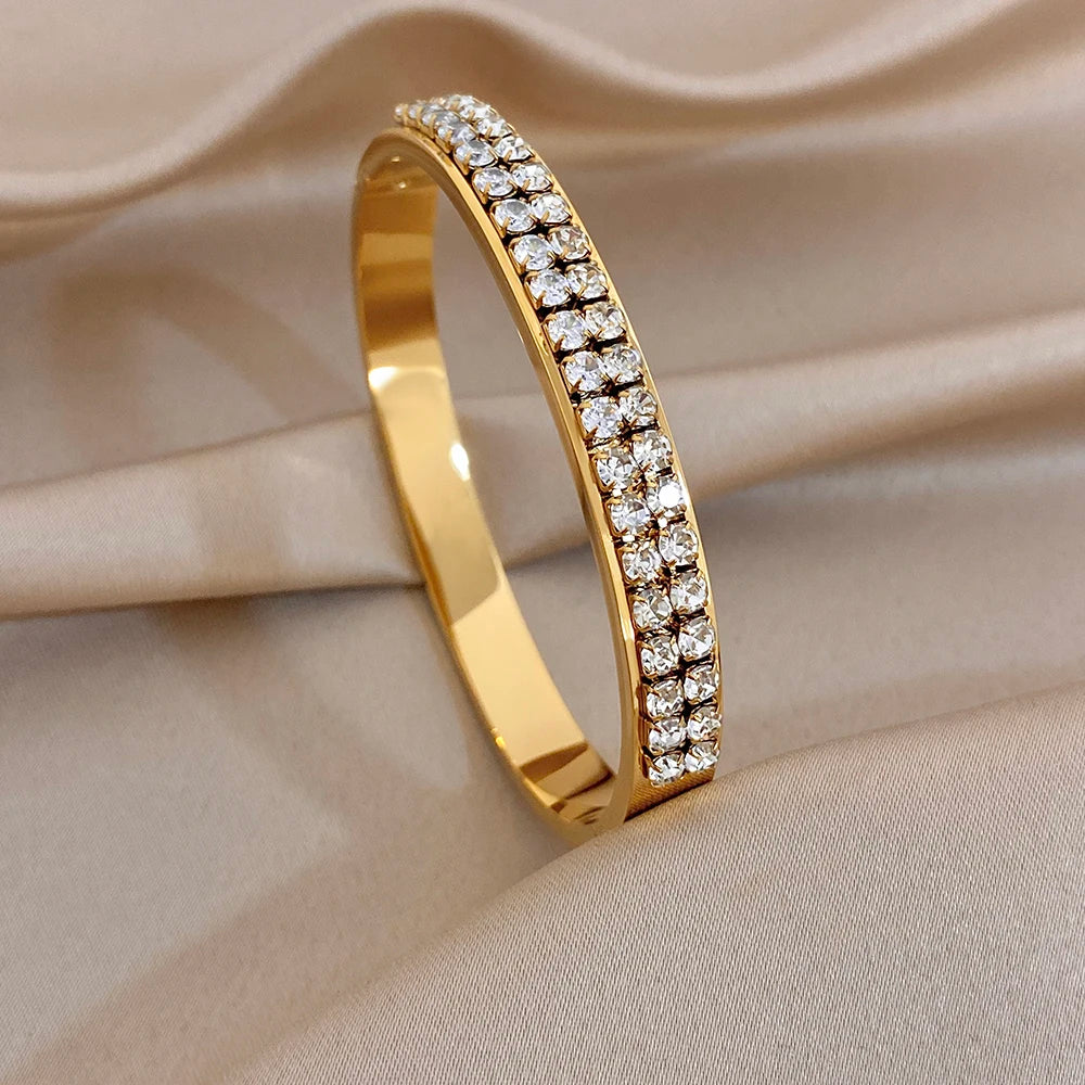 Gold-tone zircon pave bangle with sparkle stone border on smooth cuff