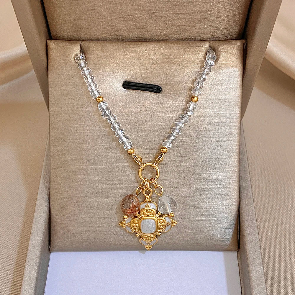 Gold-tone cross pendant necklace with clear crystal drops on a silver-and-gold beaded chain
