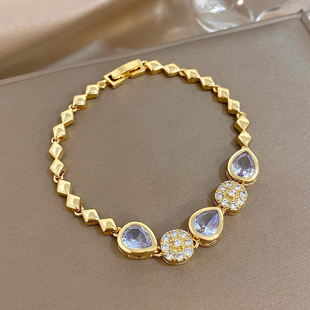 Gold-tone link bracelet with blue teardrop stones and round rhinestone accents