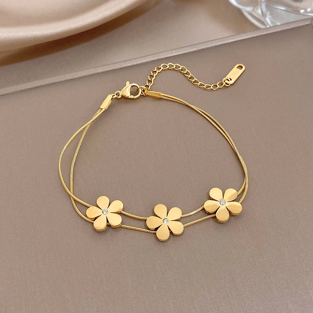 Gold double-layer snake chain bracelet with five flower charms and crystal centers