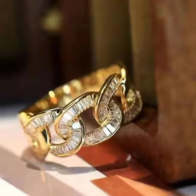 Gold-tone chain-link cubic zirconia ring with raised stone details, side view