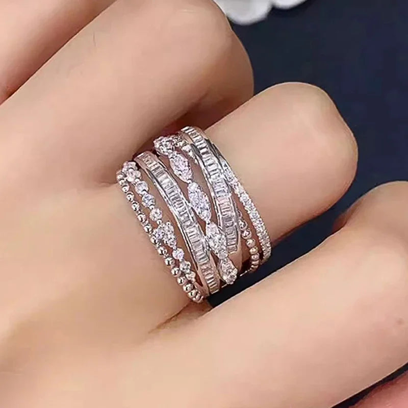 Silver multi-band cubic zirconia ring on finger with tightly set round stone rows