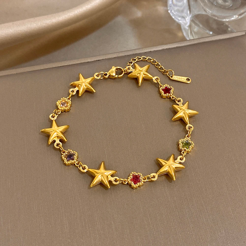 Gold slim chain bracelet with star charms and purple gemstone accents, adjustable clasp