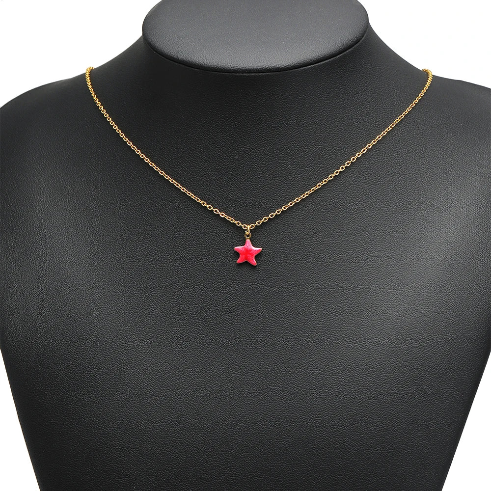 Gold-tone necklace with a red enamel star pendant on a chain