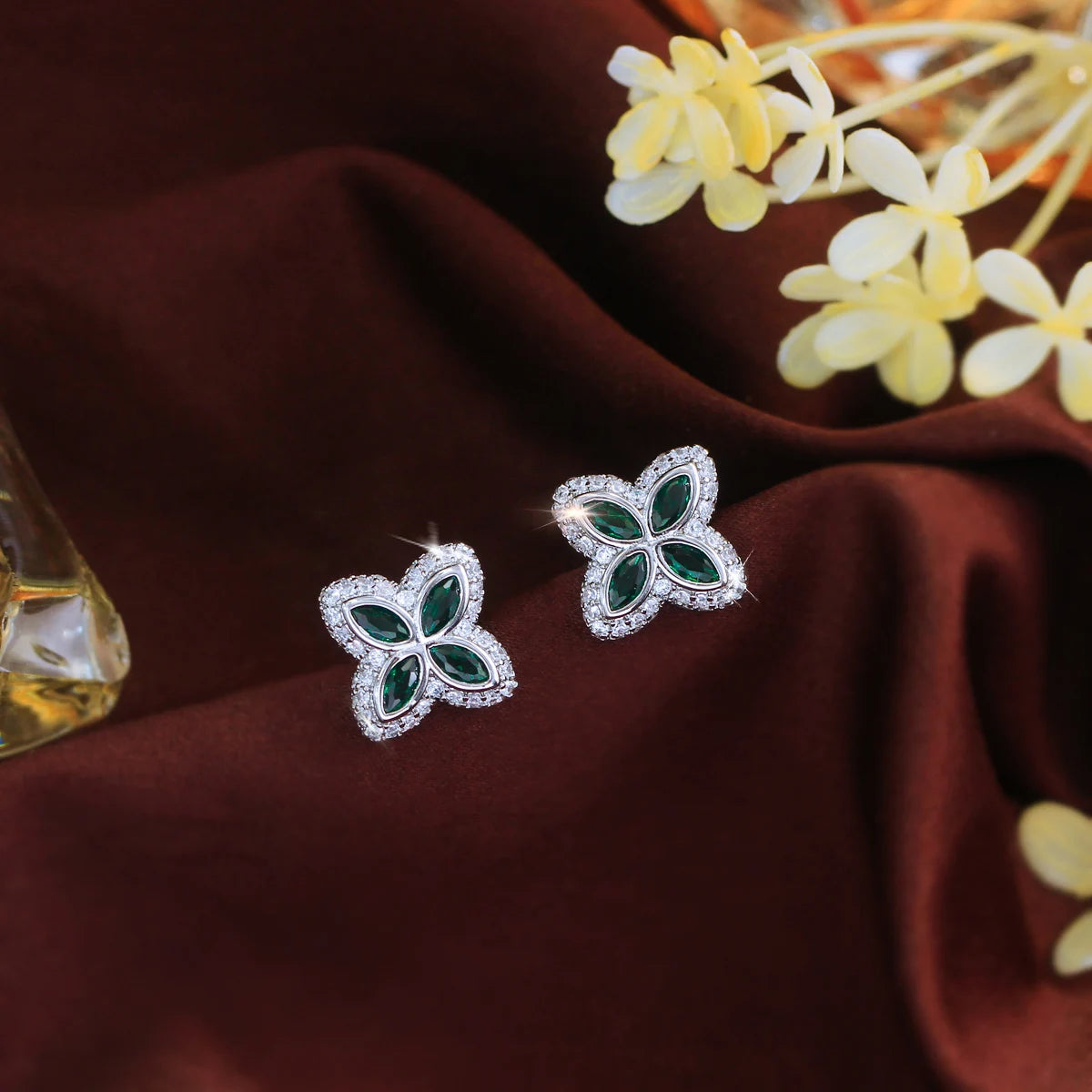 Pair of four-leaf stud earrings with green stones and clear accents