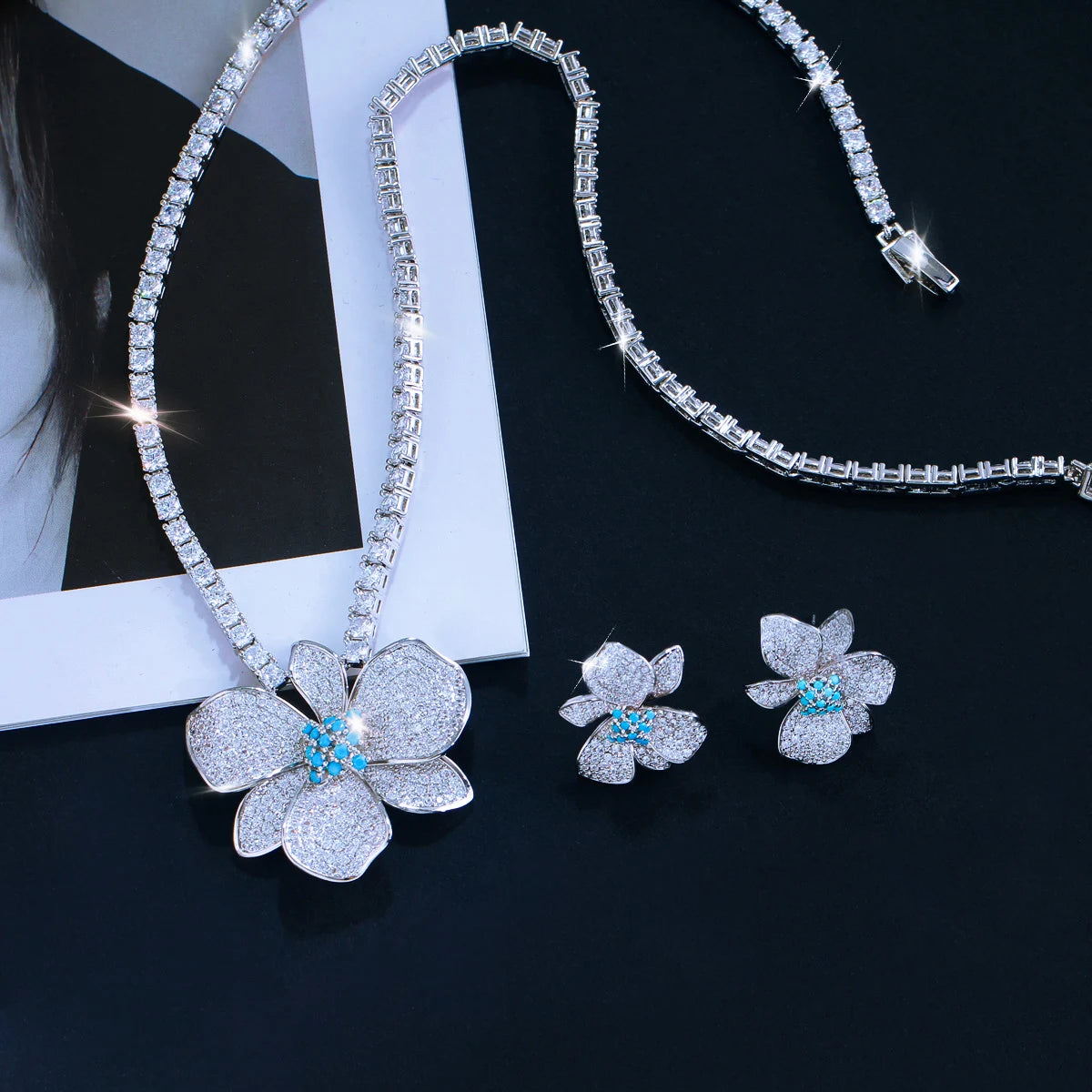 Silver-tone crystal flower necklace and two matching stud earrings laid out