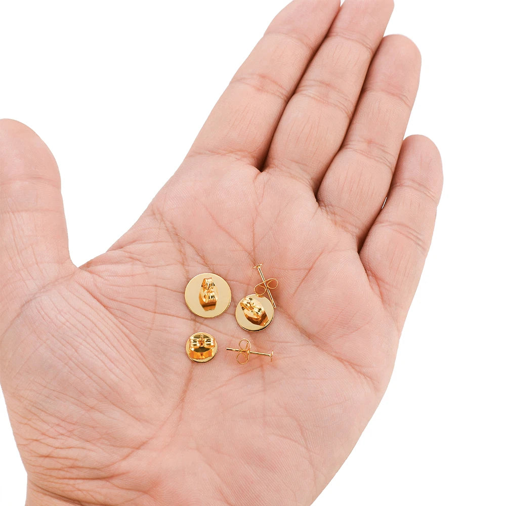 Gold round flat earring stud settings in palm, blank bases with round backing posts
