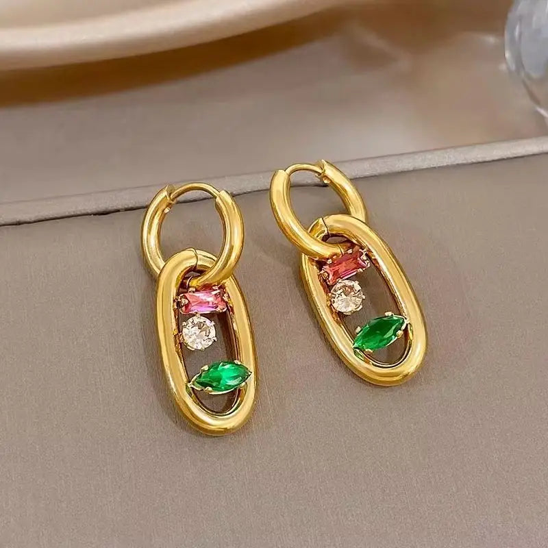 Gold hoop earrings with oval multicolor gem drop settings in red, green, and clear stones