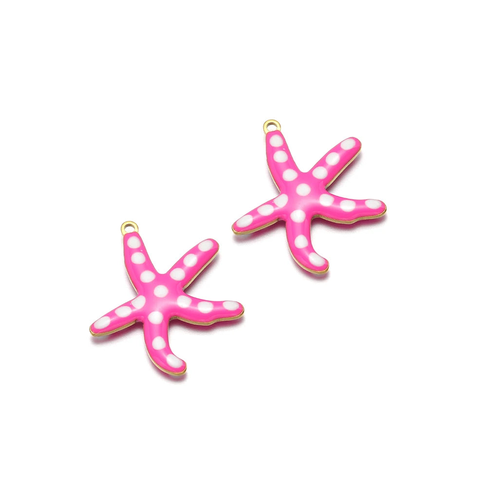 Two pink enamel starfish charms with gold-tone loops and white dot accents