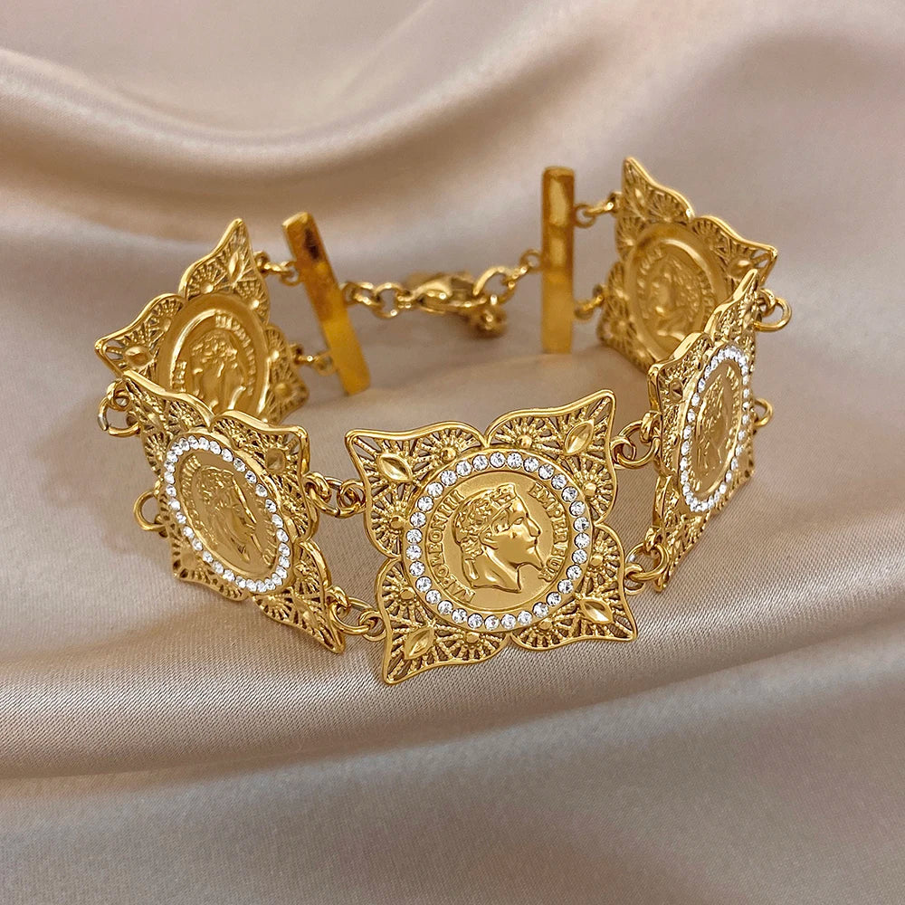 Gold-tone coin and rhinestone bracelet with sculpted link chain and oval clasp